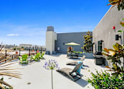 Thumbnail 1 of 31 - a patio with chairs and a table and an umbrella