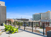 Thumbnail 2 of 31 - views of the city from the rooftop deck of a building with green chairs and a
