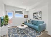 Thumbnail 24 of 31 - a living room with white walls and a blue couch