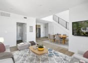 Thumbnail 18 of 31 - a living room and dining area with a staircase in a 555 waverly unit