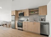 Thumbnail 12 of 45 - a kitchen with wooden cabinets and stainless steel appliances and a living room with a table