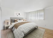 Thumbnail 15 of 50 - A bedroom with a large bed and a window with blinds.
