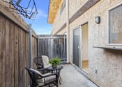 Thumbnail 14 of 50 - A patio with a table and chairs is surrounded by a wooden fence.