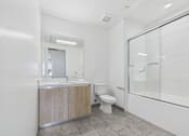 Thumbnail 41 of 45 - A bathroom with a toilet, sink, and shower.
