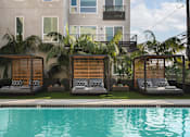 Thumbnail 11 of 31 - a swimming pool with lounge chairs in front of a building