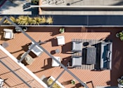 Thumbnail 13 of 119 - A top-down view of a rooftop patio with furniture and plants.