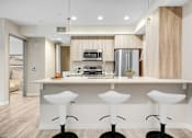 Thumbnail 2 of 10 - A modern kitchen with white countertops and bar stools.at The Blvd Lofts, California, 91436