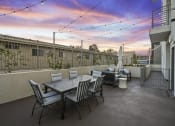Thumbnail 13 of 26 - a patio with a table and chairs and a sunset in the background
