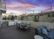 Thumbnail 14 of 26 - a patio with a table and chairs and a sunset in the background