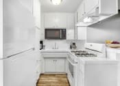 Thumbnail 1 of 10 - a white kitchen with a stove and a refrigerator