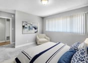 Thumbnail 8 of 10 - a bedroom with a bed and a chair and a window