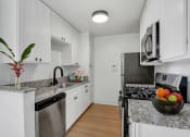 Thumbnail 1 of 10 - a kitchen with white cabinetry and granite countertops