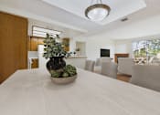 Thumbnail 2 of 17 - A dining table with a bowl of plants on it.