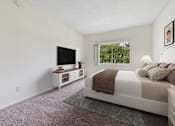 Thumbnail 9 of 17 - A bedroom with a bed, a television, and a window.