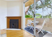 Thumbnail 6 of 17 - A room with a fireplace and sliding glass doors leading to an outdoor patio.