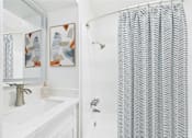 Thumbnail 20 of 82 - A bathroom with a white sink and a shower curtain with a zig zag pattern.