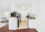 Thumbnail 9 of 82 - A white kitchen with a black oven and a white counter.
