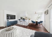 Thumbnail 11 of 82 - A living room with a blue and white striped ottoman.