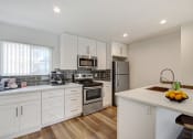 Thumbnail 1 of 76 - a kitchen with white cabinets and stainless steel appliances