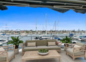 Thumbnail 64 of 135 - a patio with a couch and chairs overlooking a marina