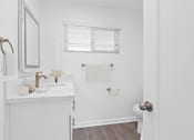 Thumbnail 70 of 135 - a small bathroom with white walls and wood flooring