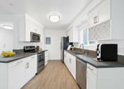 Thumbnail 53 of 135 - a kitchen with white cabinets and stainless steel appliances