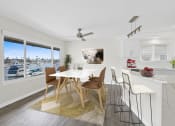 Thumbnail 73 of 135 - a dining area with a white table and chairs and a large window with a view of a