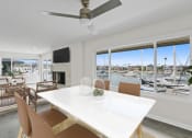 Thumbnail 76 of 135 - a living room with a white table and chairs and a view of a marina