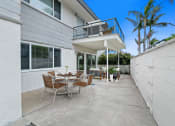 Thumbnail 57 of 135 - a patio with a table and chairs in front of a house