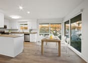 Thumbnail 38 of 135 - a kitchen with white cabinets and a wooden table with white chairs