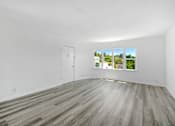 Thumbnail 14 of 20 - an empty living room with white walls and a window