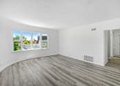 Thumbnail 12 of 20 - an empty living room with white walls and wood floors