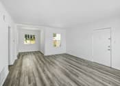 Thumbnail 13 of 20 - a living room with white walls and wood floors