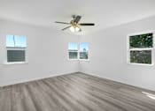 Thumbnail 16 of 20 - an empty living room with a ceiling fan and three windows