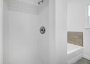 Thumbnail 18 of 20 - a white bathroom with a shower and a tub