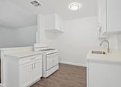 Thumbnail 11 of 38 - an empty kitchen with white cabinets and a white counter top