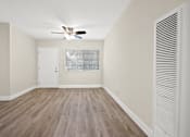 Thumbnail 29 of 38 - an empty living room with white walls and a ceiling fan