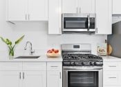 Thumbnail 7 of 25 - a kitchen with white cabinetry and stainless steel appliances