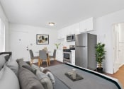 Thumbnail 10 of 25 - a living room with a couch a table and a refrigerator