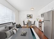 Thumbnail 9 of 25 - a living room with a couch a table and a refrigerator