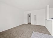 Thumbnail 4 of 38 - an empty living room with white walls and carpet and a white door