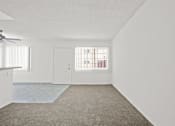 Thumbnail 5 of 38 - the living room and kitchen of an apartment with white walls and carpet