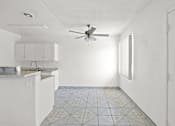 Thumbnail 3 of 38 - an empty kitchen with white cabinets and a ceiling fan