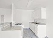 Thumbnail 2 of 38 - an empty kitchen with white cabinets and a counter top