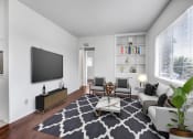 Thumbnail 3 of 25 - a living room with a couch coffee table and a tv on the wall