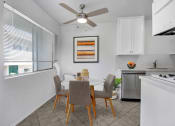 Thumbnail 2 of 25 - a dining area with a table and chairs and a ceiling fan