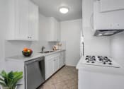 Thumbnail 1 of 25 - a kitchen with white cabinetry and a white stove top oven