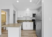 Thumbnail 1 of 208 - A kitchen with a granite countertop and stainless steel appliances.