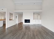 Thumbnail 11 of 208 - A large, empty room with a fireplace and wooden floors.