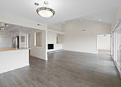Thumbnail 16 of 208 - A spacious living room with a kitchen area in the background.